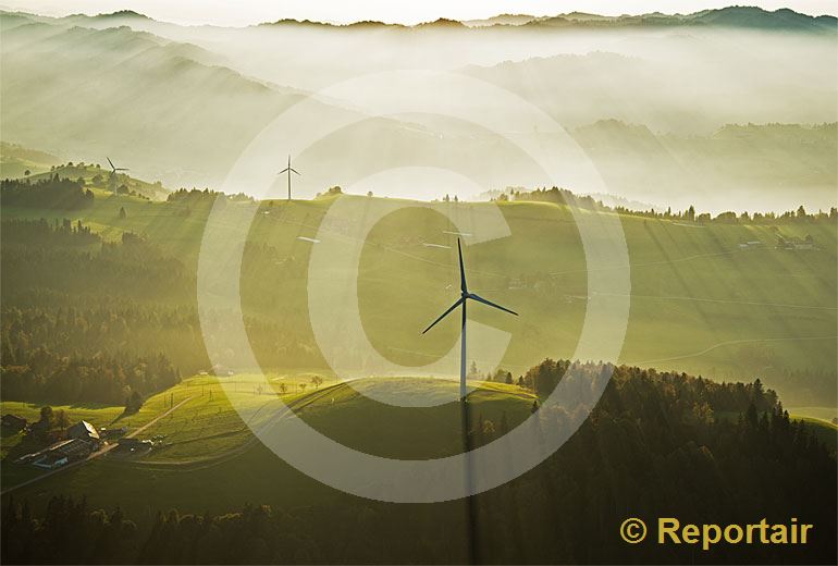 Foto: Windkraftwerke im nebligen Abendlicht der Biosphäre Entlebuch. (Luftaufnahme von Niklaus Wächter)